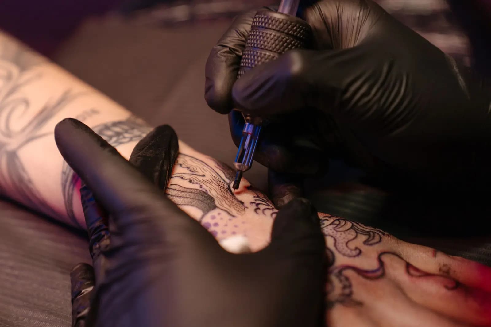 Tattoo artist wearing gloves working at a clean studio station.